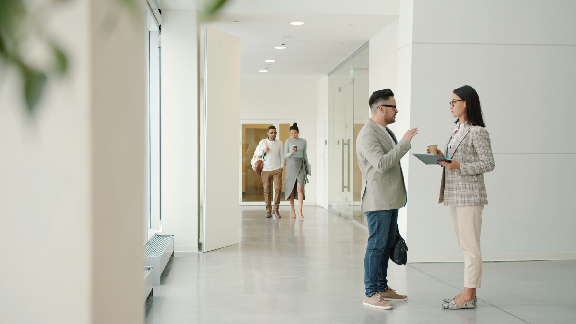 Conversation in a bright office corridor